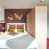 Zenitude Hotel Residences - Grenoble Alpexpo room with double bed, wall art and bedside lamp in Grenoble
