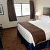 Cobblestone Inn & Suites - Denison guest room with king bed, window and bedside lamp