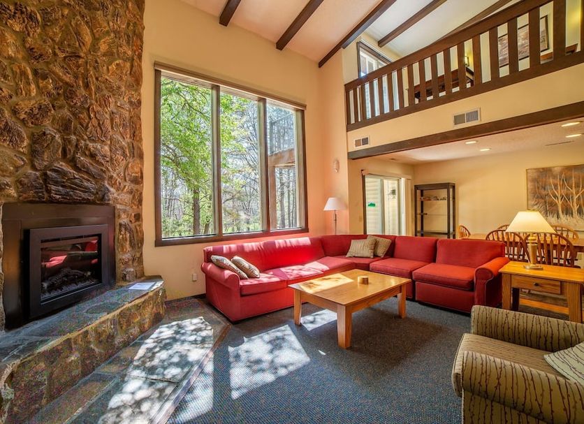 Mountainside Villas at Massanutten in McGaheysville living room with stone fireplace, red sectional and loft