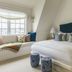 Gardiner House Newport guest room with king bed, window seat, and blue accent decor