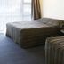 Raceway Motel Whanganui room with two beds, chair, and window with curtains