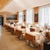 HC Resort Lignano Sabbiadoro dining room with set tables, tall windows and modern seating