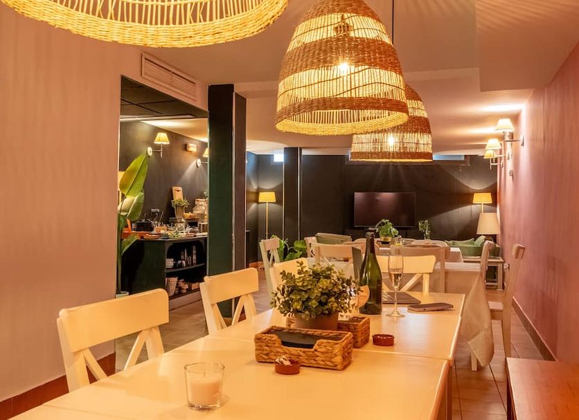 I AM La Posada Hotel and Apartment in Benalmádena dining room with woven pendant lights and set tables