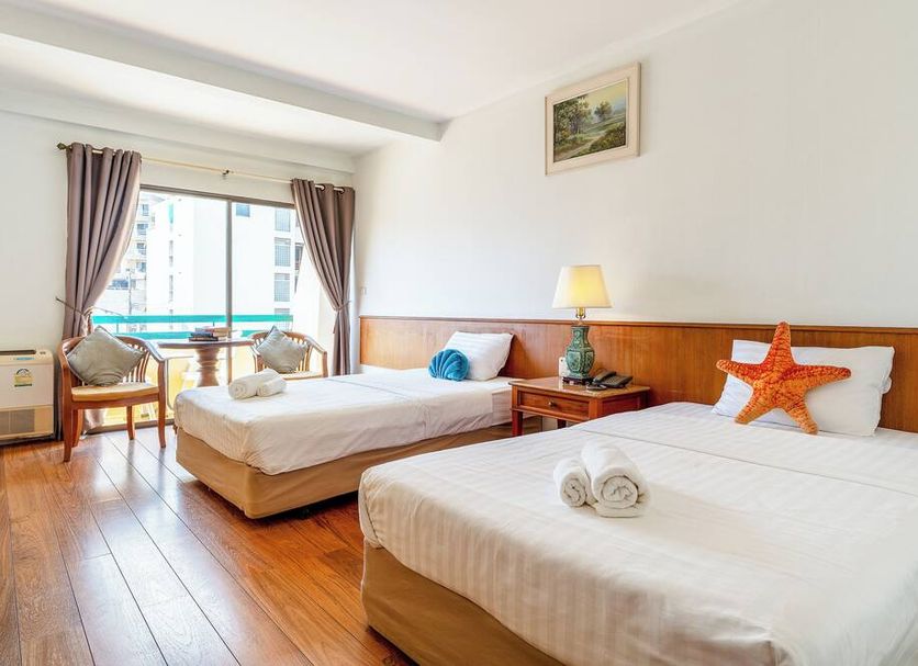 Sirin Hotel Hua Hin room with two beds, balcony view, wood floors, and bright seaside-style decor
