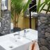 The Yuppi Hippi Beachpackers Hostel Anjuna bathroom with twin white sinks and stone-accented wall
