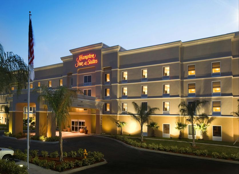 Hampton Inn & Suites Lake Wales hotel exterior at dusk with palm trees and lit windows