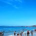 Hon Rom Central Beach Resort in Mũi Né with guests on a sandy beach and calm blue sea