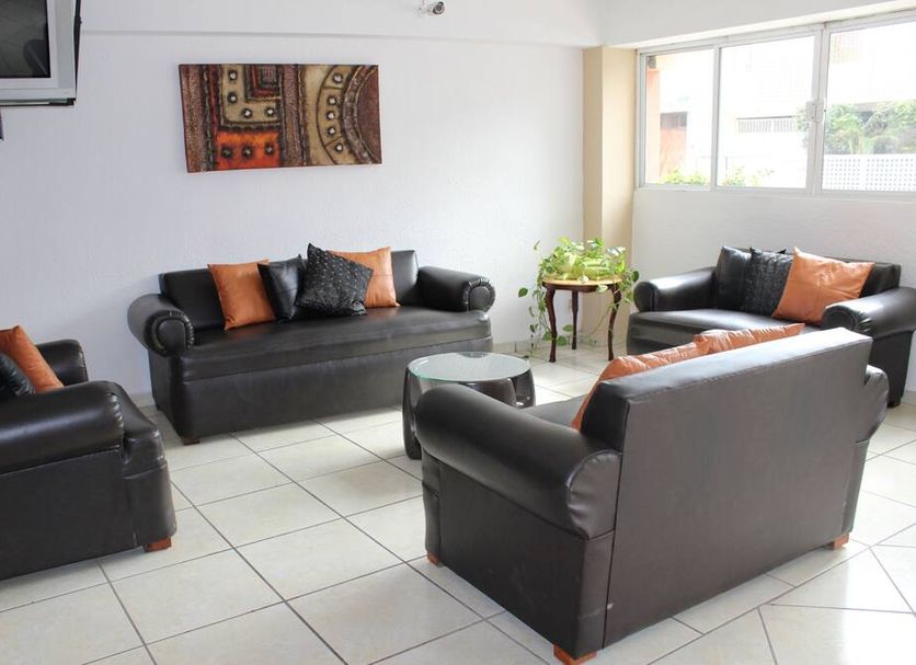 Hotel Posada del Carmen in Veracruz lounge with black leather sofas, wall art, and large windows