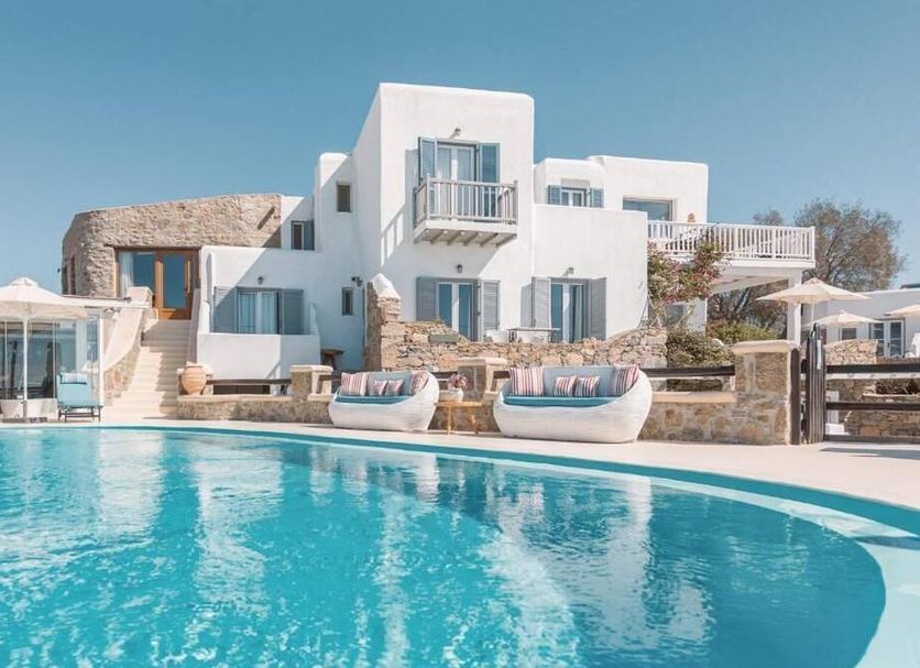 Villa Konstantin, Mykonos: white hotel with curved pool, loungers and sea-view balconies
