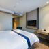Motel168 Shanghai Qi Bao Inn guest room with bed, desk, wall-mounted TV and modern lighting in Shanghai