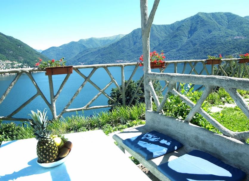Hotel Glavjc in Torno with lake-view terrace, bench, pineapples, flowers and mountain backdrop