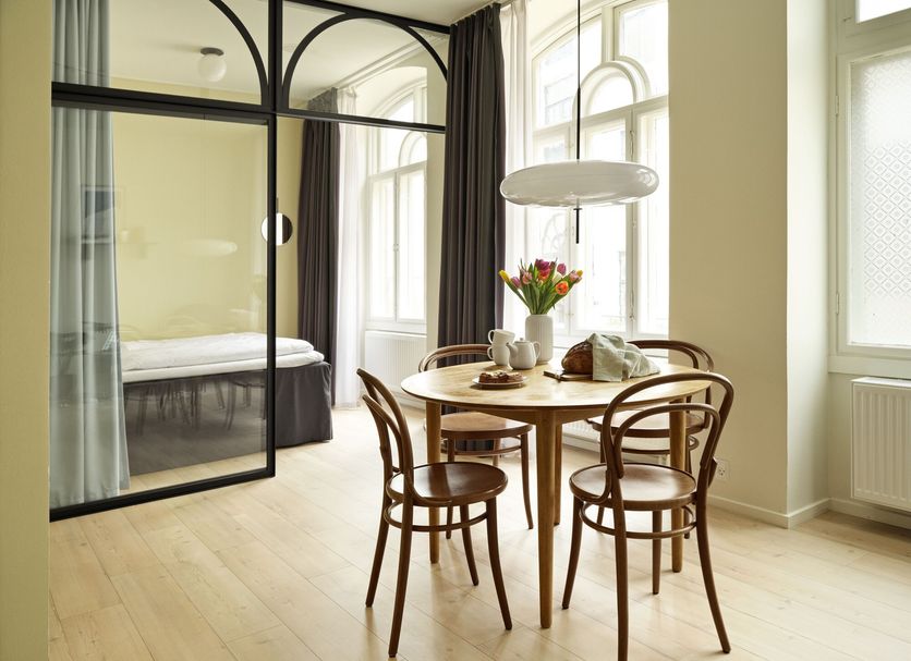 Aperon Apartment Hotel in Copenhagen, bright apartment suite with dining table and glass-partitioned bedroom