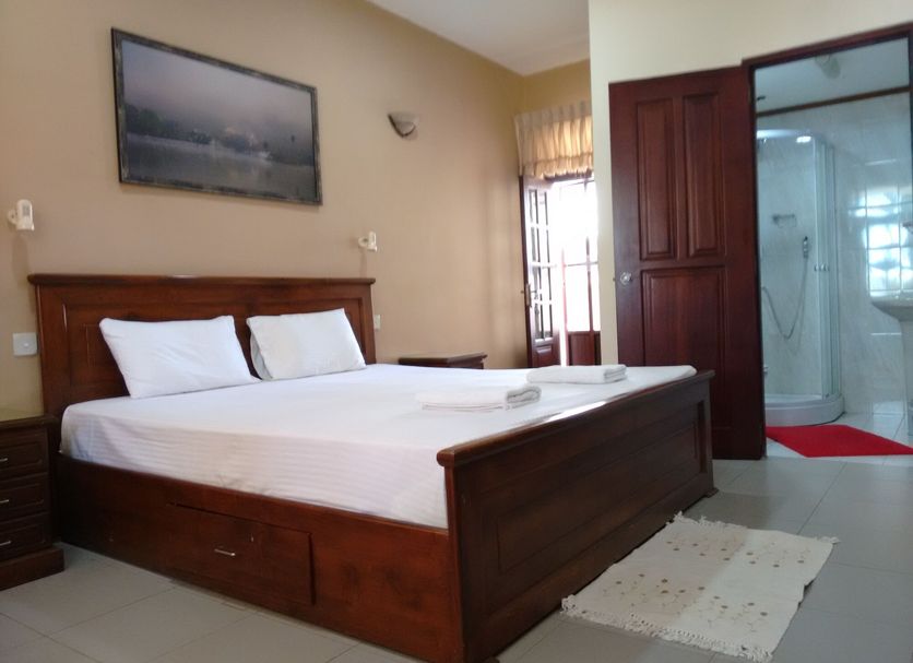 Janishi Residencies, Negombo: double bed in guest room with attached bathroom doorway