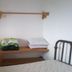 Oasis Tepoztlán guest room with bed, wooden shelf, and window in Tepoztlán
