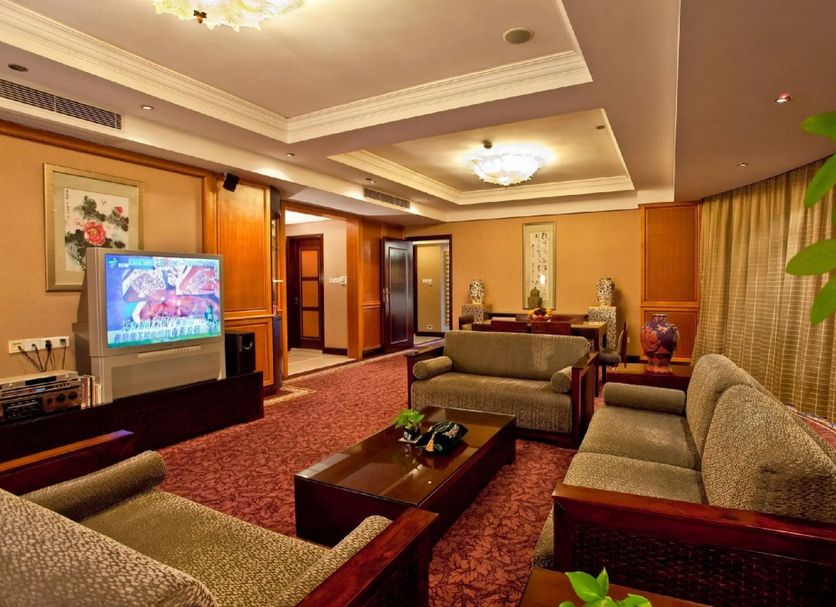 Chinflux Mandarin Hotel Dongguan lounge with sofas, coffee table, TV and warm ceiling lights