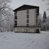 Hostel pod Voglom in Ribčev Laz, snow-covered hotel exterior beside frosty trees