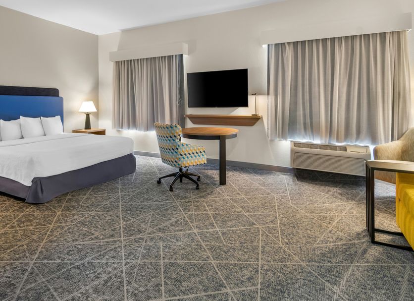 Hampton Inn & Suites Fort Worth/Forest Hill guest room with king bed, desk, TV, and large windows
