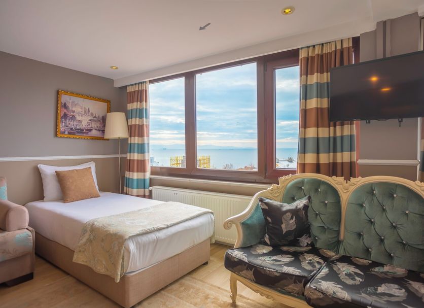 Tashkonak Hotel in Istanbul guest room with twin beds, bay window sea view, and wall-mounted TV