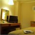 Hotel Shin-ei guest room in Toyota with a bed, desk, TV and bedside lamp