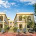 Raj Palace Resort in Sawāi Madhopur with a courtyard and palm trees under a blue sky
