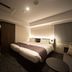 Grids Premium Hotel Osaka Namba room in Osaka with a double bed, seating nook, and dark carpeted floor.
