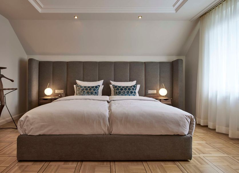 Parkhotel Gütersloh room with a king bed, bedside lamps, and sheer curtains in Gütersloh