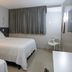 Allegro Hotel in Goiânia guest room with two beds, curtained window and white chair