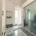 Vingt Sept in Polignano a Mare: bright bathroom with frosted glass shower, vanity, and balcony door