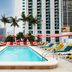 citizenM Miami World Center rooftop pool with lounge chairs, palms and Miami skyline views