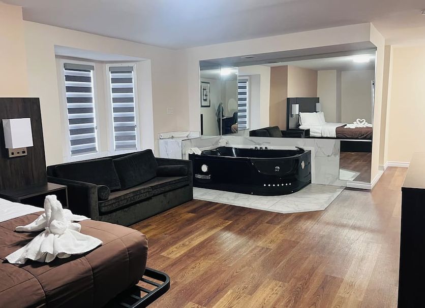 Falls Lodge and Suites Niagara Falls room with jetted tub, sofa, and king bed