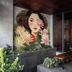 Triple E Hotel Metro Ben Thanh in Ho Chi Minh City entrance with mural, bench, and potted plants