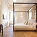Myr Palacio Vallier in Valencia, elegant four-poster bedroom with desk and herringbone wood floor