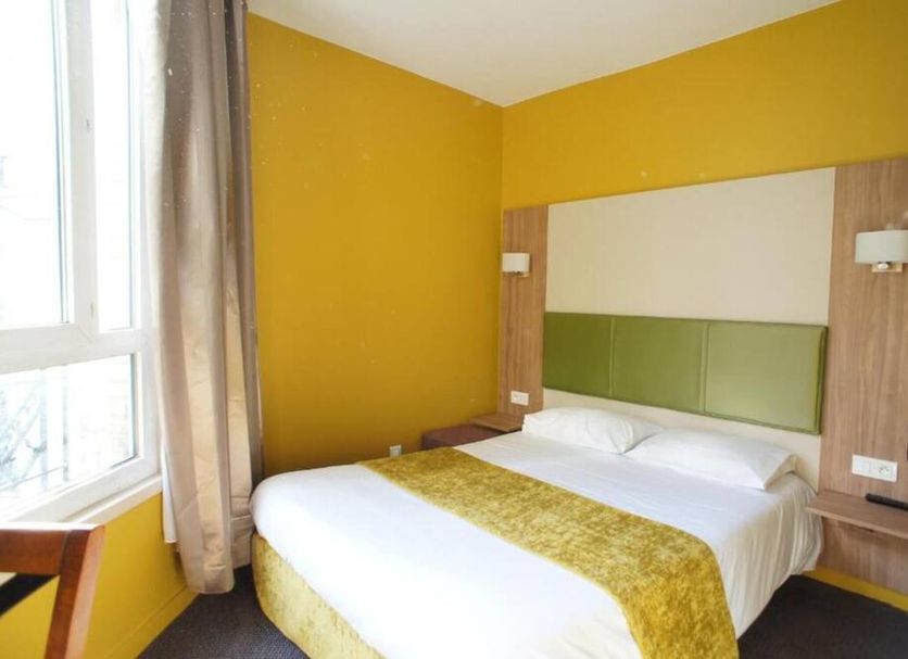 Hôtel de France Boulogne-Billancourt room with double bed, yellow walls and window beside the bed