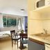 Vacancéole - Le Domaine De Chames room in Vallon-Pont-d'Arc with bed, dining table and kitchenette