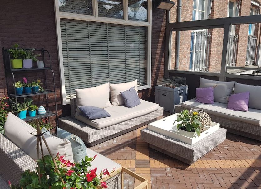 De Eenhoorn in Oostburg: rooftop terrace with cushioned seating, potted plants and coffee table