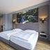 Michel Hotel Waldkirchen am Badepark room with twin beds and forest artwork in Waldkirchen
