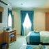 Alaxis Hotel Kuala Lumpur guest room with twin beds, desk, and blue curtains