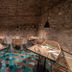 Médousa Suites in Taormina, stone-walled dining room with woven chairs and patterned tile floor