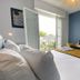 Hôtel La Maison des Dunes room with balcony doors, bed, wall TV and small desk in Erdeven