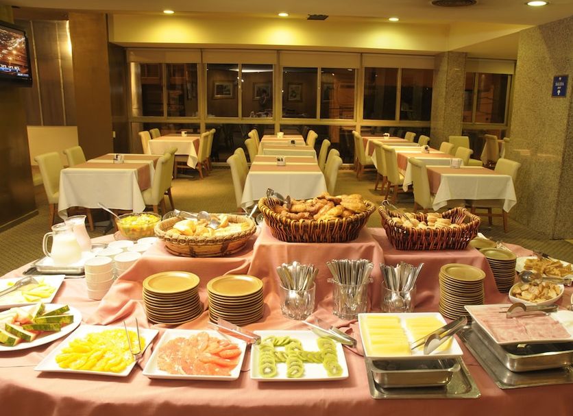 Ariston Hotel Rosario buffet breakfast setup in dining room with tables and chairs