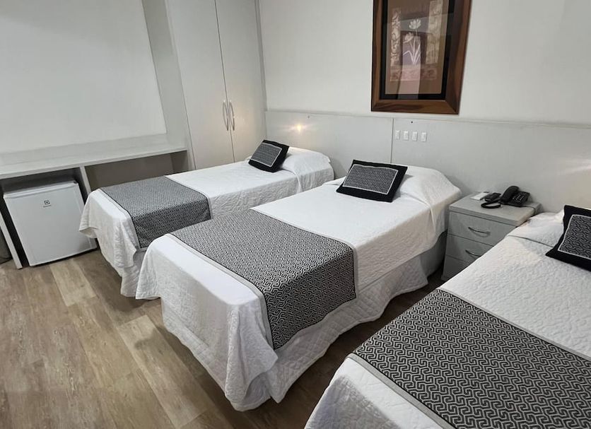 Hotel Geranium in Balneário Camboriú: triple room with three single beds and a small mini fridge