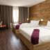 Hôtel Énergie Shawinigan guest room with two beds, wood accent wall, desk and window curtains