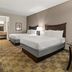 Americas Best Value Inn Byhalia guest room with two beds, desk, and adjoining vanity area