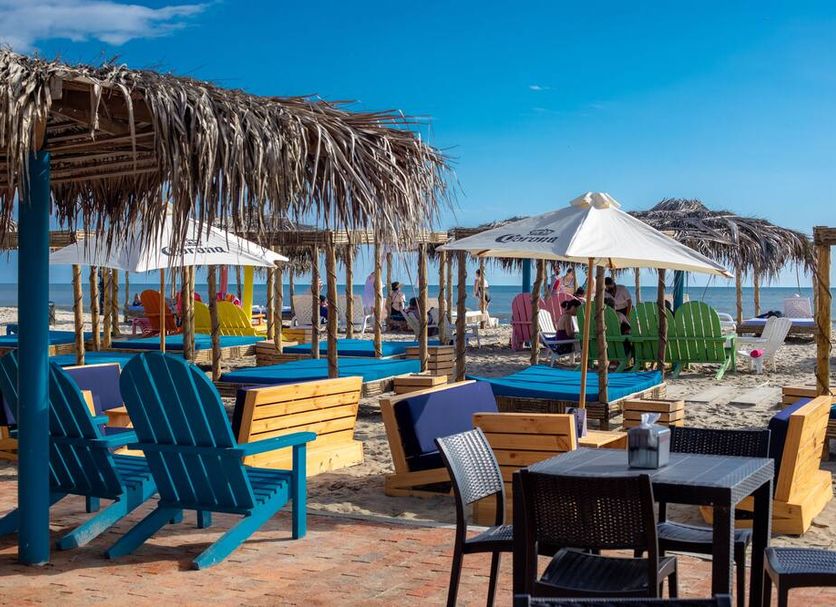 Playa Paraíso in Playas beachfront seating with thatched umbrellas, lounge chairs, and ocean view