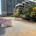 Jomtien Beach Residence in Pattaya, gravel entrance gate with signs, parked car, and high-rise buildings