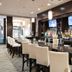 Holiday Inn & Suites Red Deer South by IHG bar with white stools and TV screens in Red Deer