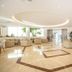 Niriides Beach in Kolympia: bright hotel lobby with beige seating, marble floor, and potted plants