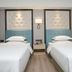 Master Hotel Huizhou twin guest room with two beds, tufted headboards and bedside lamp