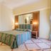 Raeli Hotel Lazio Rome guest room with striped bed, mirrored wardrobe and ornate wall decor