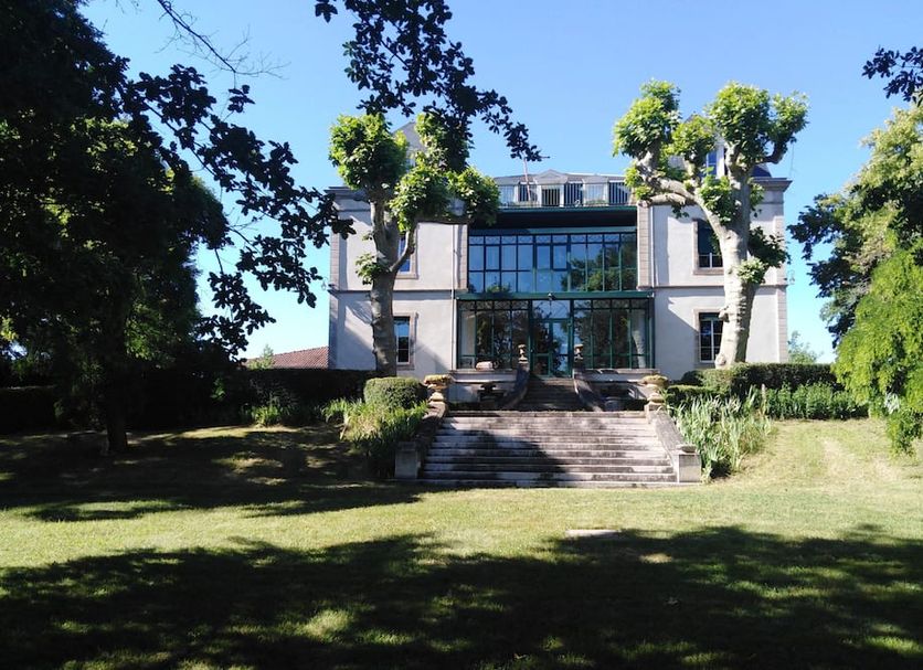 Hôtel La Métairie in Cordes-sur-Ciel, exterior view of a building with steps and lawn amid trees